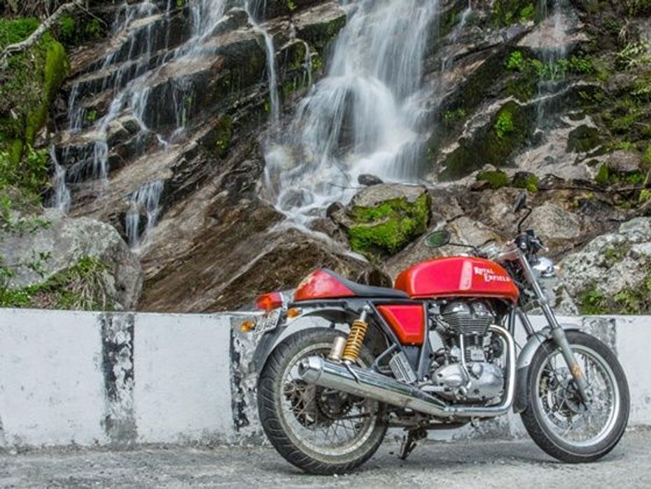 Royal Enfield Continental GT poses next to a waterfall 2014 Tour of Bhutan