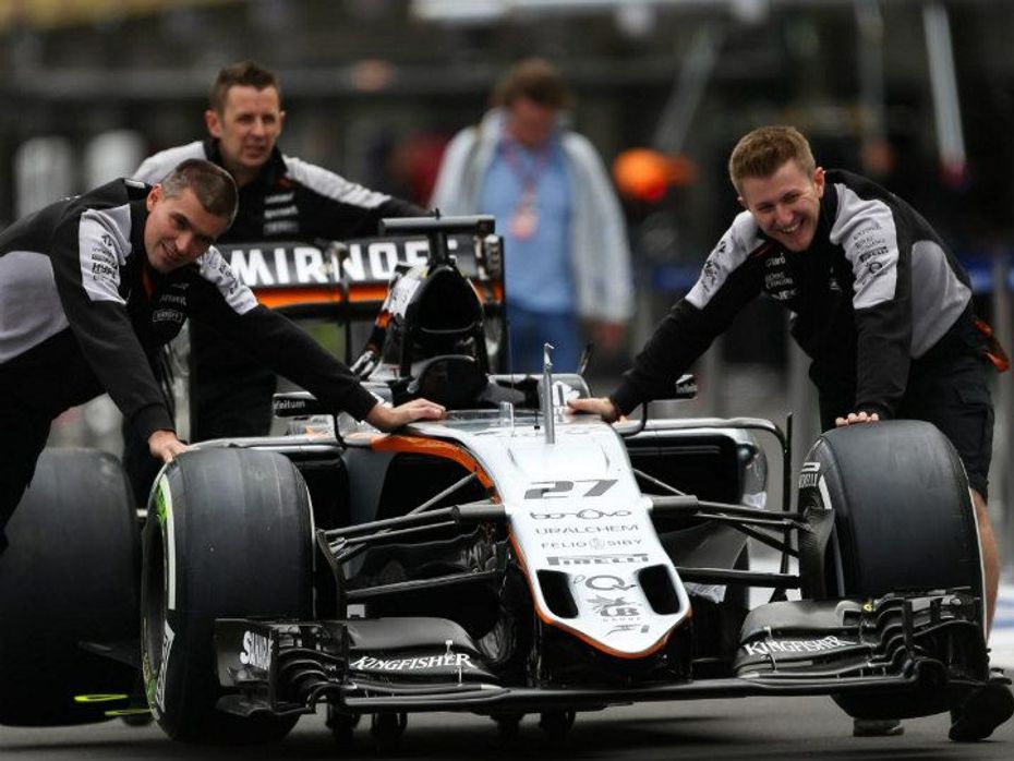 Technicians of Force India having a good time while pushing the car