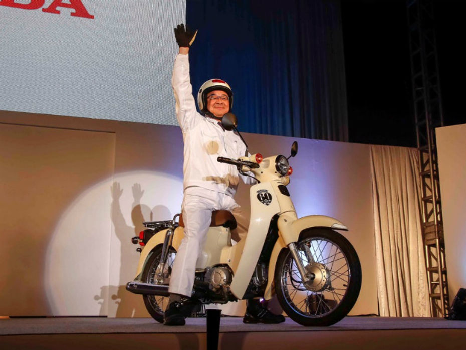 Honda CEO, Takahiro Hachigo atop a 2018 Super Cub during the 100-million-unit celebration